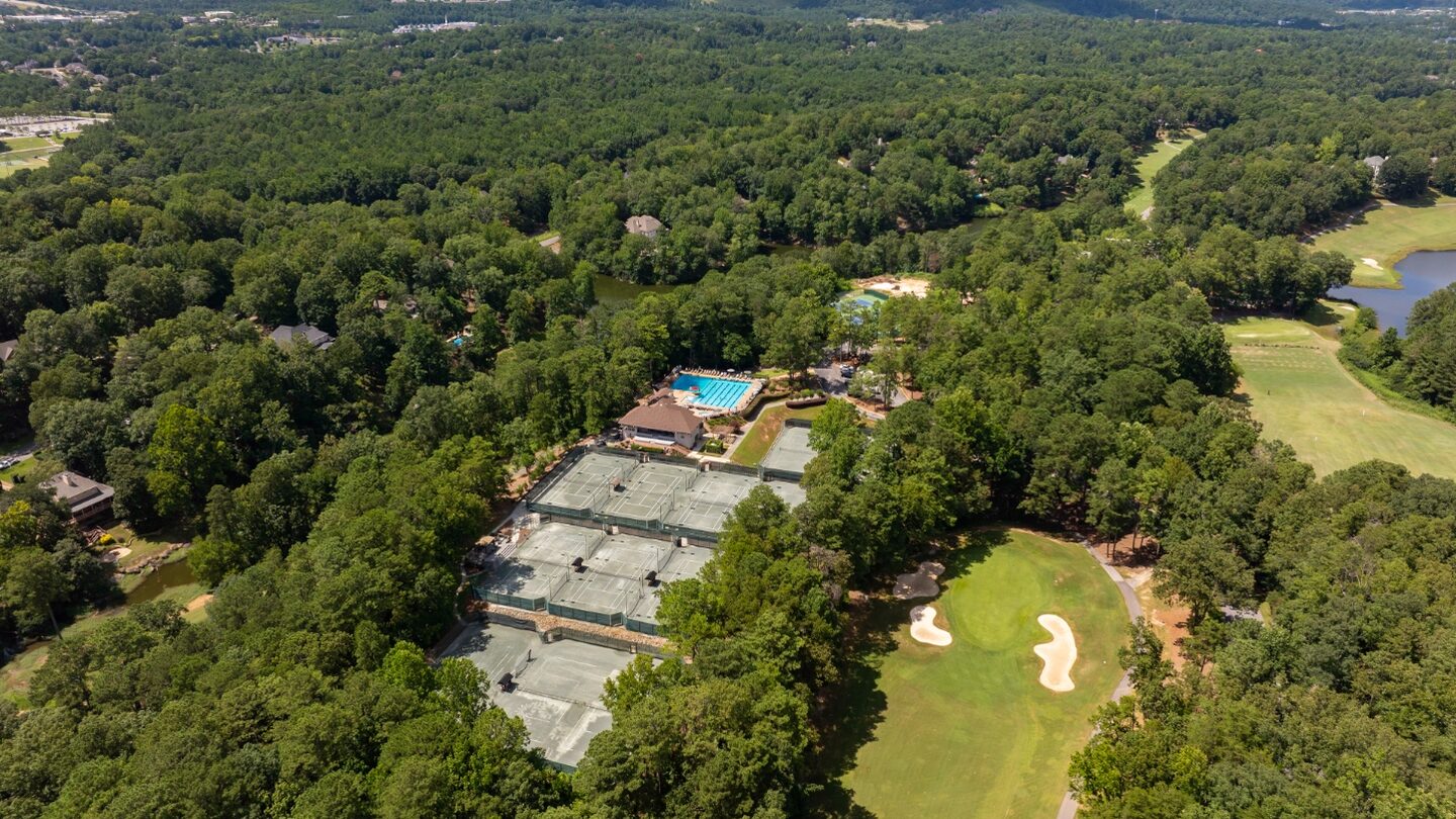 Aerial view of Riverchase Country Club showing the tennis complex, the pool deck, the clubhouse and a bunkered green